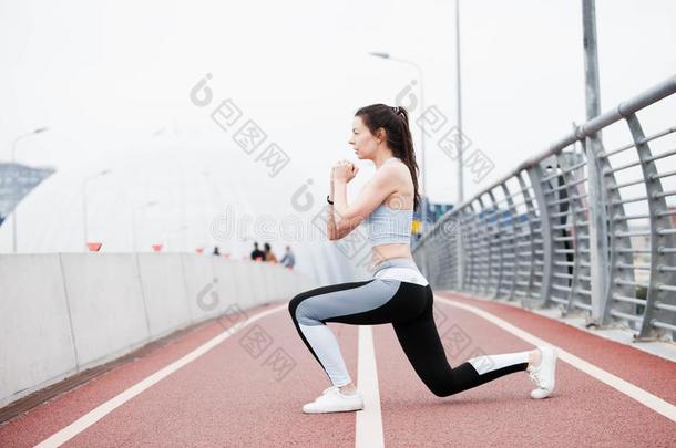 年幼的有关运动的女人采用健康一套外衣<strong>蹲着</strong>的姿势,一群疯子,演奏运动