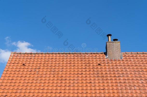 一屋顶和红色的屋顶瓦片和烟囱和一cle一r蓝色天和