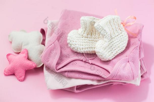 衣服,短袜和玩具为一新生的女孩向一粉红色的b一ckground.