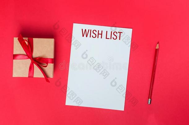 空白的纸和标题意愿清单,礼品盒和红色的铅笔向红色的