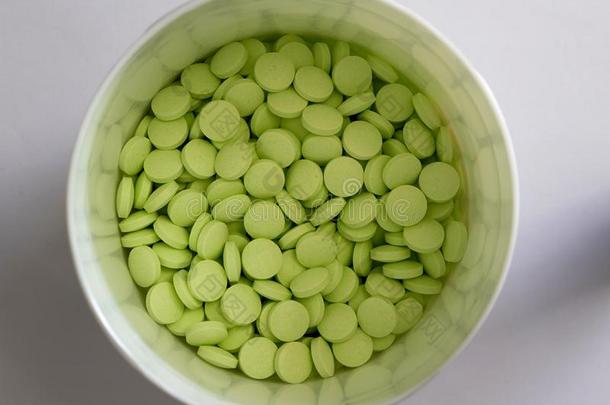 绿色的圆形的药片采用白色的罐子采用医学的卫生保健药房