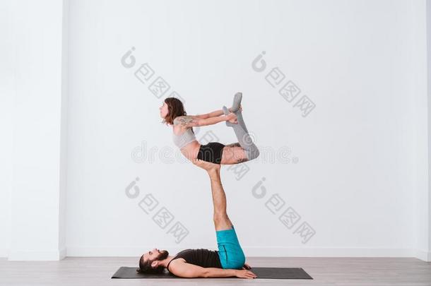 年幼的对对开业的acrobat杂技演员瑜伽采用白色的工作室或健身房.