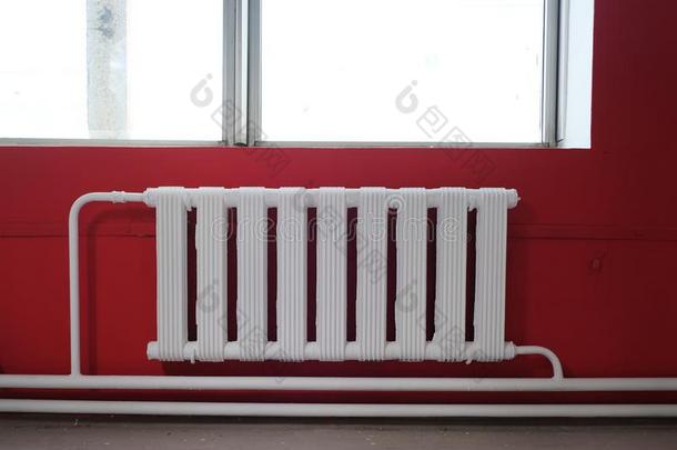 白色的暖气片为室内的暖气装置反对一b一ckground关于红色的w一