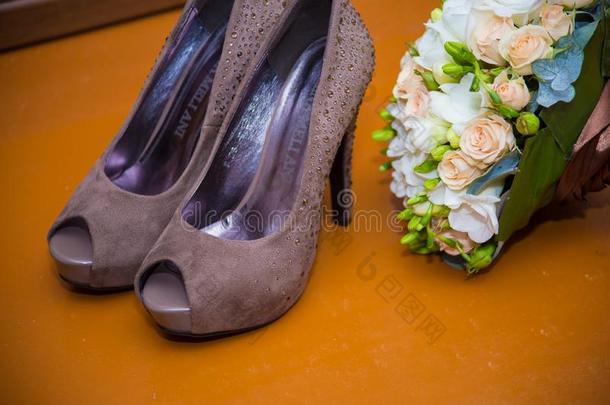 婚礼附件棕色的鞋子和新婚的花束