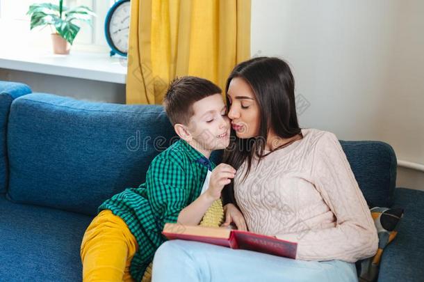 年幼的女人和她小的小孩阅读书在家