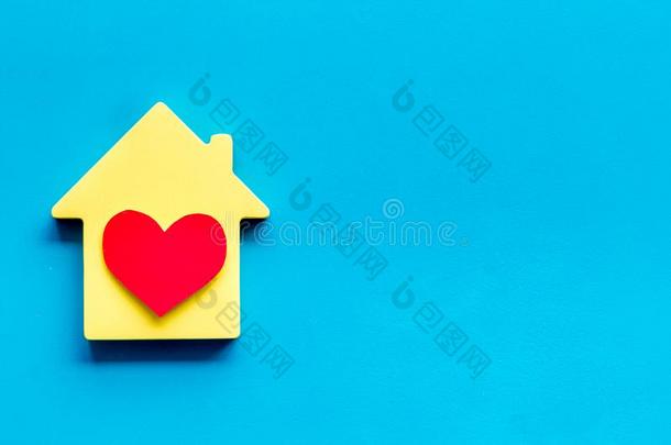 幸福的生活和家观念.房屋剪下的图样和心偶像向蓝色