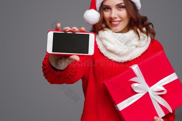 欢乐的女人和圣诞节赠品展映智能手机
