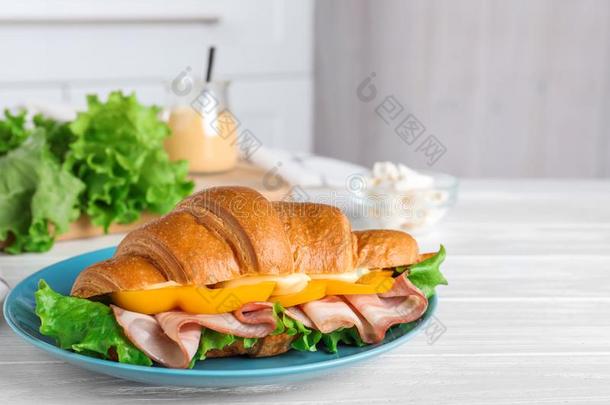 美味的羊角面包三明治和火腿向白色的表