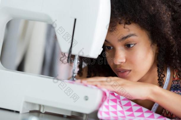 聚焦的年幼的裁缝使用缝纫机器