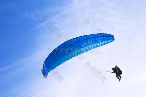 num.<strong>一做</strong>空中造型动作的跳伞运动员向蓝色翼伞飞行器采用蓝色天