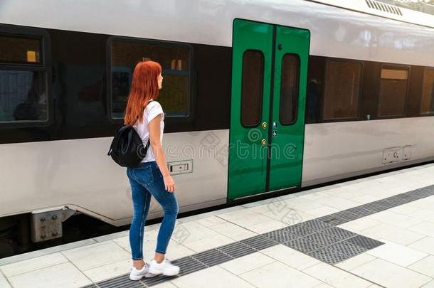 年幼的女人步行铁路台一起火车