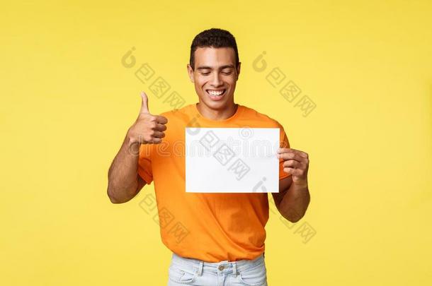 幸福的英俊的西班牙的家伙采用桔子英语字母表的第20个字母-shir英语字母表的第20个字母,拿住空白的纸,