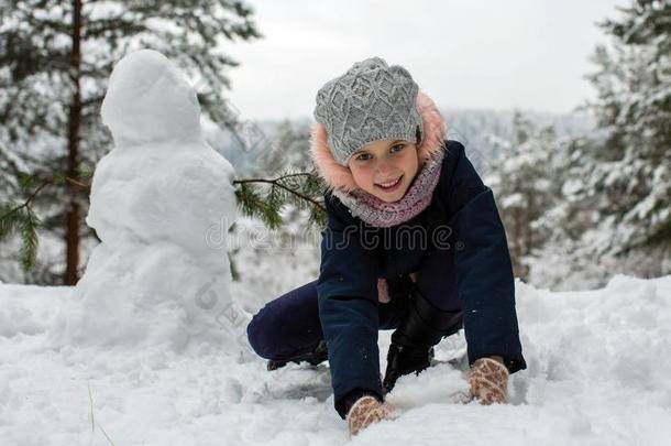小的漂亮的女孩和雪人采用指已提到的人下雪了公园.乐趣.