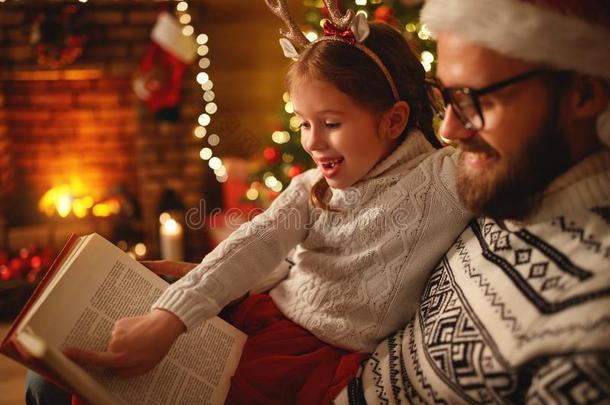 圣诞节前夕.家庭父亲和小孩阅读魔法书在homonym同音异义词