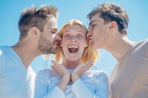 白肤金发碧眼女人幸福的女孩获得吻从两个英俊的男孩.一个卫生纸品牌