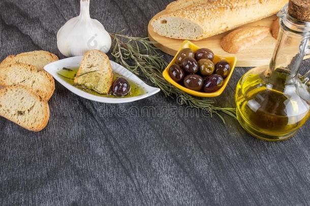 橄榄油调味汁采用白色的碗&希腊人橄榄向木材背景.