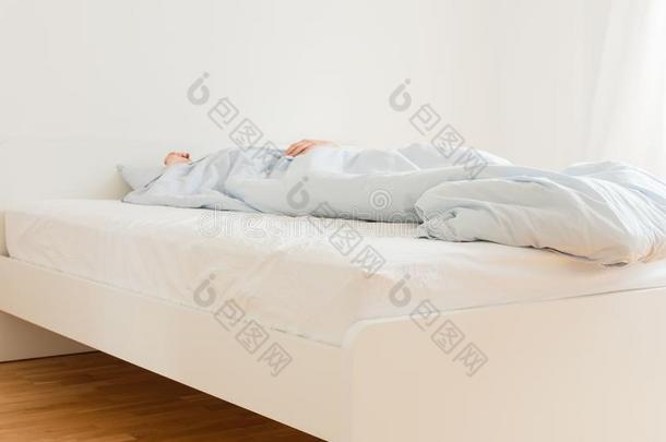 男人睡眠向一白色的床
