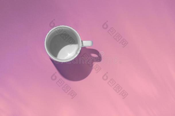 空的茶水杯子向粉红色的纸背景.咖啡豆马克杯从在上面.英语字母表的第13个字母