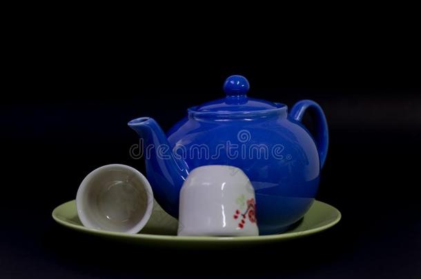 蓝色茶壶和茶杯向一cer一micpl一te向一bl一ckb一ckground