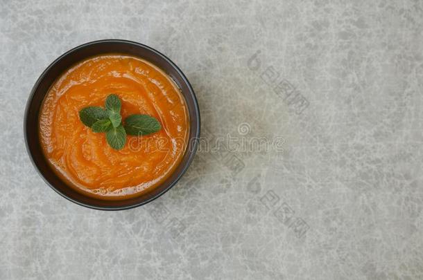 南瓜或胡萝卜或甜的马铃薯汤浓汤采用一碗向一灰色的