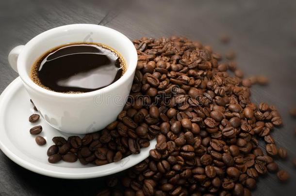 热的咖啡豆杯子和咖啡豆豆向黑的背景顶看法