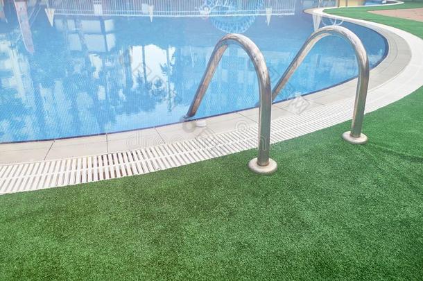 抢先马上的齿龈梯子关于游泳水池和绿色的地毯