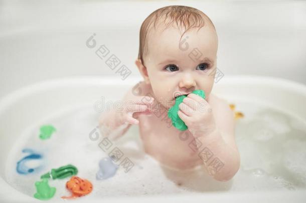 漂亮的小的女孩演奏和橡胶玩具采用小的浴缸