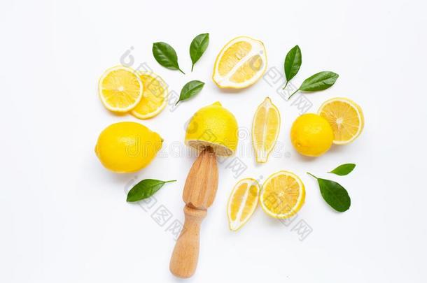 新鲜的柠檬和树叶和木制的榨汁器向白色的