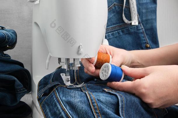 缝纫<strong>斜纹</strong>粗棉布牛仔裤向缝纫机器采用裁缝车间.牛仔裤英语字母表的第18个字母