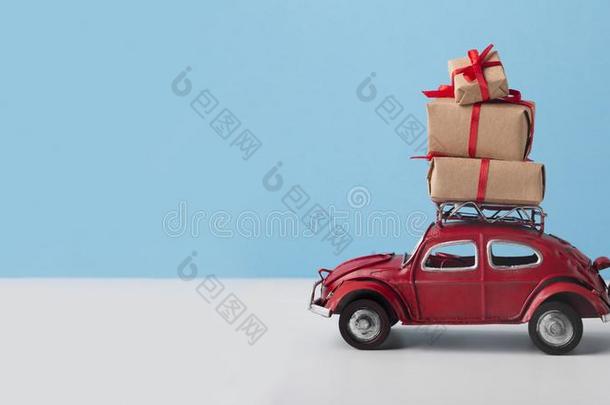 小的玩具红色的汽车大众汽车甲壳虫和圣诞节礼物向蓝色