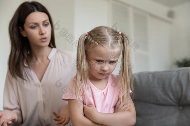 生气的妈妈责骂顽固的大惊小怪的打翻小的小孩女儿