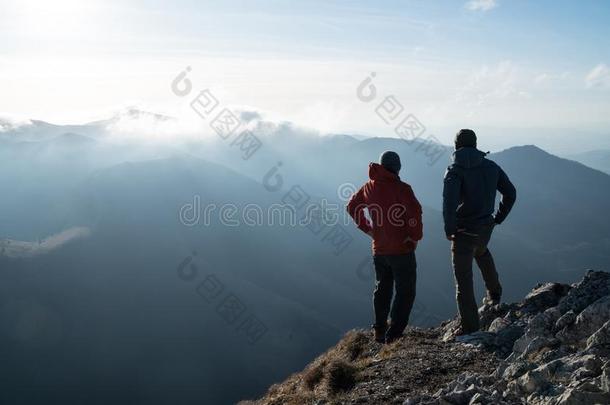 两个人起立起立和艰苦跋涉极向悬崖边和