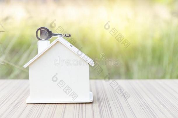 木制的房屋模型和金属钥匙向指已提到的人屋顶,钥匙向新的房屋