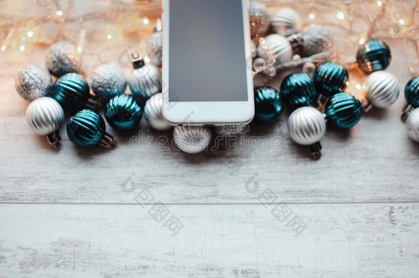 白色的智能手机和屏幕向木制的背景和圣诞节