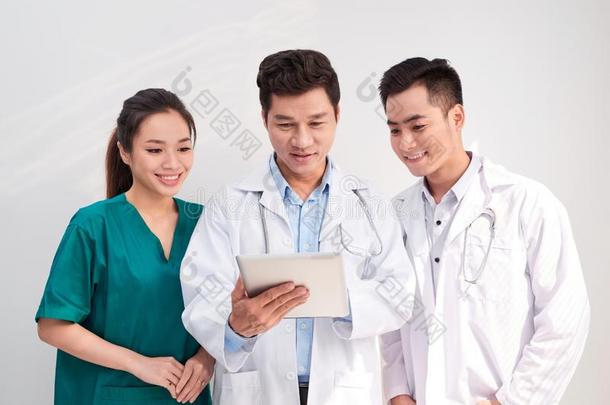 医学的队包括医生和护士有样子的在一苹果平板电脑/表