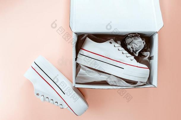 白色的时髦的白色的旅游鞋采用尤指装食品或液<strong>体</strong>的)硬纸盒盒向多乳<strong>脂</strong>的或似乳<strong>脂</strong>的桃子后面