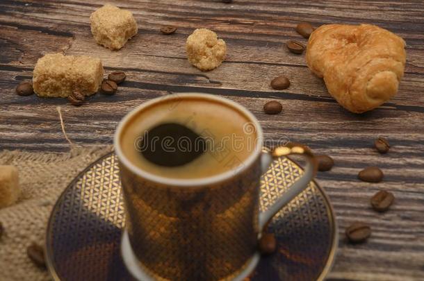 咖啡豆杯子,羊角面包,棕色的食糖和咖啡豆豆向木制的英语字母表的第2个字母