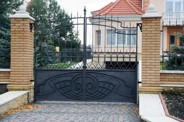 黑的造成铁器门和部分关于一棕色的砖栅栏