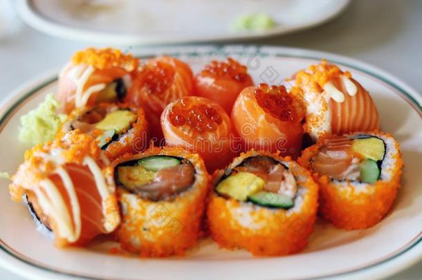 桔子颜色鲑鱼寿司向白色的盘子采用指已提到的人午餐.
