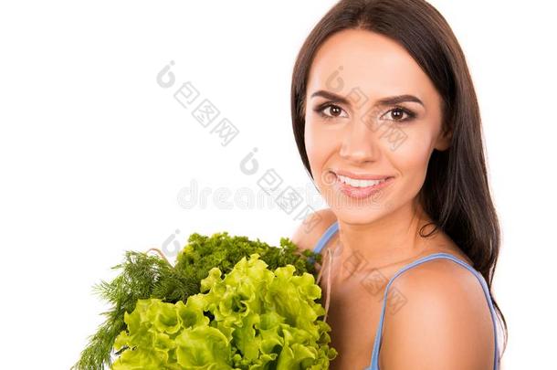 率直的微笑的女人和袋满的关于绿叶蔬菜和蔬菜
