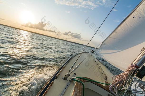 帆船运动小船帆船运动快的进入中指已提到的人日落向波浪起伏的海和胡麻