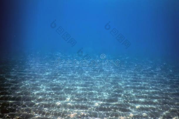 在水中的蓝色洋,沙的海底部在水中的背景