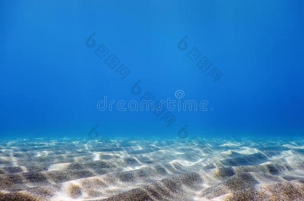 在水中的蓝色洋,沙的海底部在水中的背景