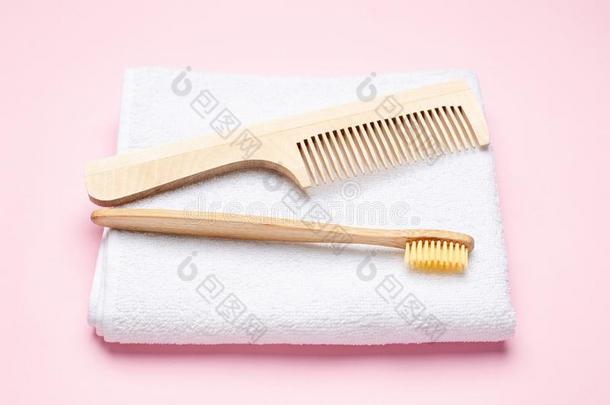 ec向omy经济木制的牙刷,梳子和白色的沐浴毛巾向粉红色的后面