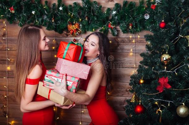 两个微笑的女人采用红色的衣服和许多赠品盒在近处癌症危险等级与信息系统