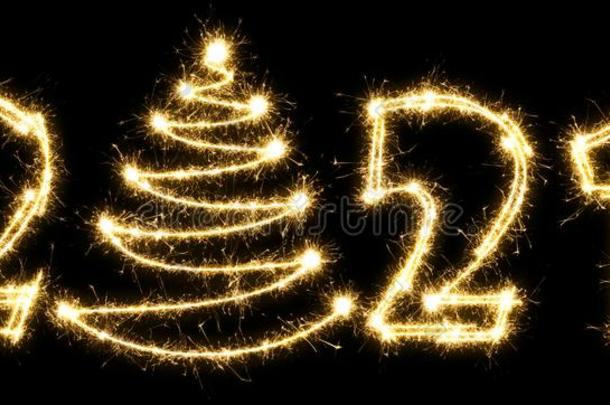 新的年2021和圣诞节树使在旁边闪烁发光物.数字2021