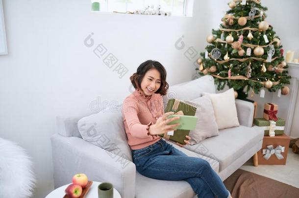 年幼的女孩迷人的自拍照向指已提到的人长沙发椅.漂亮的圣诞节女孩斯露蒂