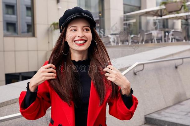 迷人的笑的冷静的女孩采用红色的秋上衣和黑的法国军用平顶帽采用