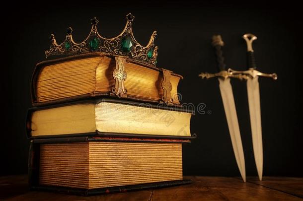 低的钥匙影像关于美丽的女王/国王王冠越过古老的书一