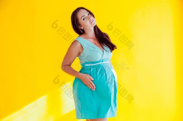 一怀孕的女人在之前分娩黄色的背景